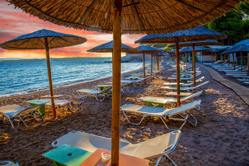 wonderful straw awnings on the beach and morning on idyllic Greek island Spetses