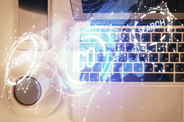 Blockchain theme hologram drawings over computer on the desktop background. Top view. Double...