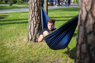 Young guy has a rest in summer in a hammock