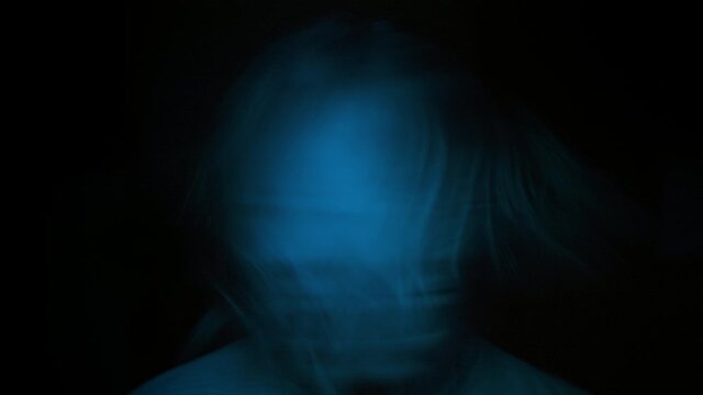 Close up portrait woman angry in blue light, effect burnt film. Woman screaming looks camera