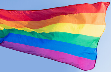 The LGBT flag is developing against the sky. Symbol of equal rights for lesbians, homosexuals, transgender people, bisexuals. Pride month. Rainbow flag.