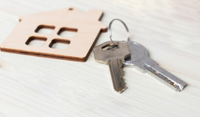 Mini house figurine with keys on an office desk. Top view