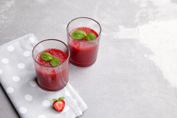 Fresh strawberry mousse dessert in two glasses on grey concrete background