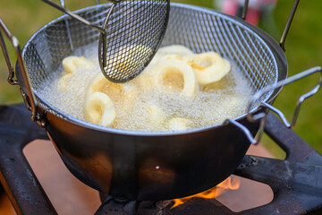 Primo piano di anelli di totano nella pentola che friggono nell’olio bollente