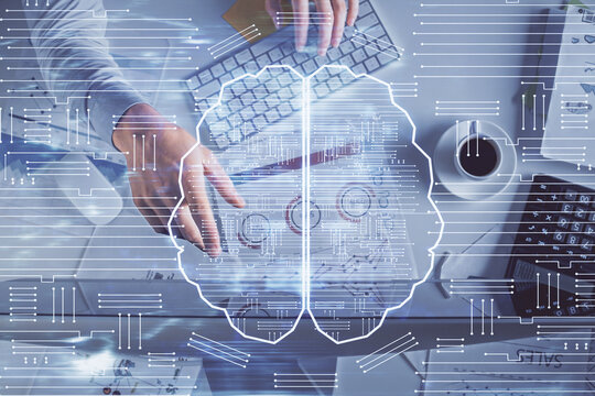 Double exposure of man's hands typing over computer keyboard and brain hologram drawing. Top view. Ai and data technology concept.