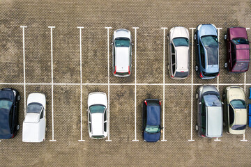 Top down aerial view of many cars on a parking lot of supermarket or on sale car dealer market. © bilanol