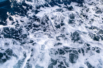 Top down aerial view of sea water surface. White foam waves texture as natural background.