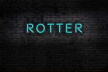 Neon sign. Word rotter against brick wall. Night view