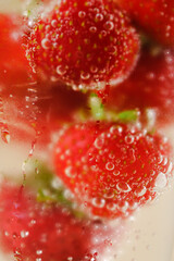 Macro closeup of isolated cocktail glass with red strawberries, sparkling water focus on bubbles . High quality photo