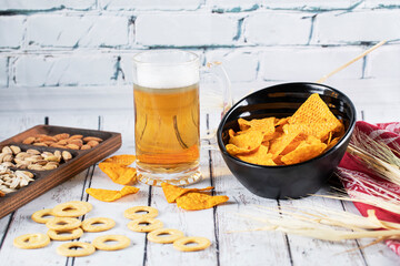 A glass of drink served with snacks