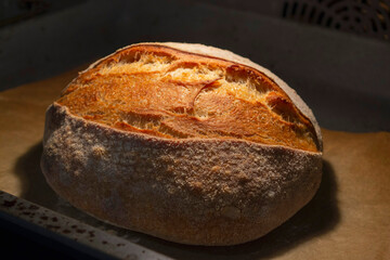Artistic composition in dim electric light. Homemade crispy yeast-free bread (French roll) inside...