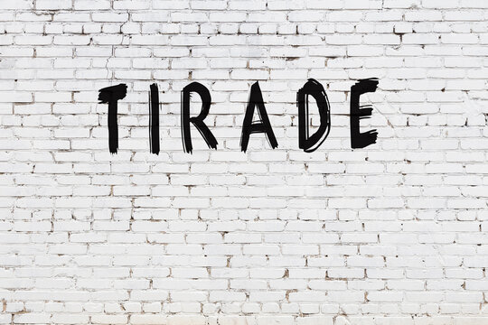 White wall with black paint inscription tirade on it