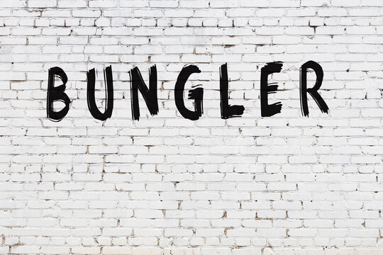 Inscription bungler painted on white brick wall