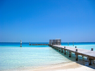 Wooden Fishing and Boating Beach Pier Extending into Beautiful Blue Ocean at a Tropical Resort