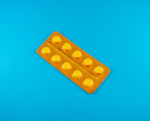 Blister naranja que contiene pastillas blancas de uso medicinal 