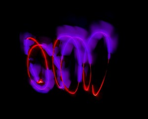 light painting abstract background. curves and waves of purple and red light against a black background