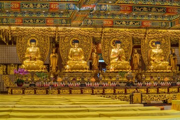 This image shows a lavish, elaborate golden buddha temple in Hong Kong.