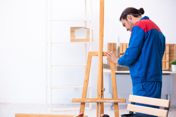 Young male contractor working in workshop