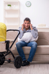 Young father looking after newborn baby at home