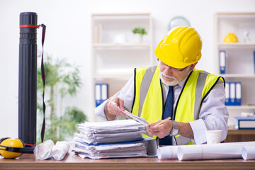 Old male architect working in the office