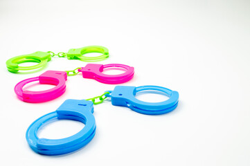 The toy handcuffs are available in green, pink and blue. On a white background.