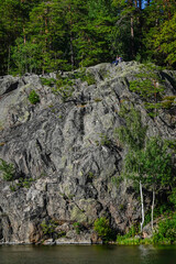 Stockholm, Sweden A couple sit on a cliff outside on Lake Malaren.