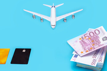 plane pack of euros and plastic cards on a blue background, lack of money for travel and flights, air transport crisis