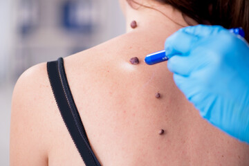 Young woman visiting male doctor dermatologist