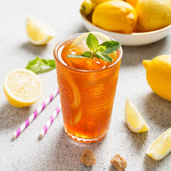 Iced tea with lemon, mint and ice cubes. Iced cold summer drink.