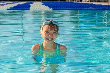 Young girl smiling while swimming in a swimming pool