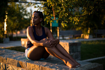 A woman enjoys the sunset after working out