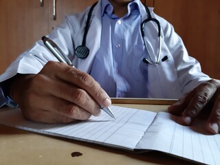 Picture of a doctor writing a prescription in his clinic 