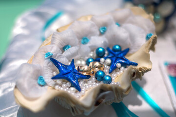 Shell wedding rings with pearls and starfish. Nautical style wedding ceremony.