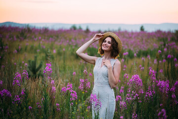 a girl in a straw hat in a field of flowers