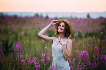 a girl in a straw hat in a field of flowers