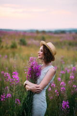 a girl in a straw hat in a field of flowers