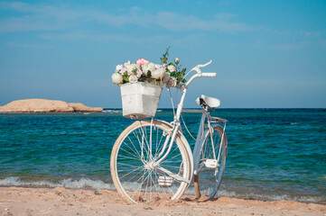 Fototapeta na wymiar Wedding bicycle with flowers on the beach.