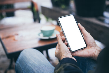 cell phone mockup image blank white screen.woman hand holding texting using mobile on desk at coffee shop.background empty space for advertise.work people contact marketing business,technology
