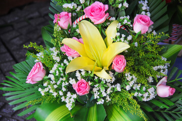 Beautiful bouquet of yellow lilly and pink rose flowers in a gift basket nature background
