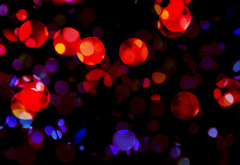 Abstract multicolored particles on black background.	