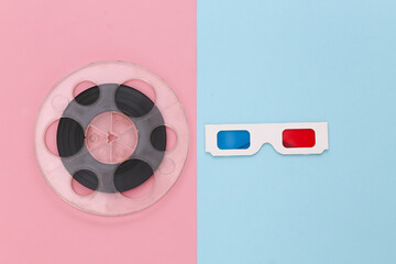 Film reel and anaglyph 3D glasses on pink blue background. Entertainment industry. Cinema. Top view