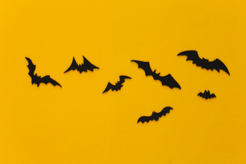 Halloween background, decorations and scary concept. Black bats fly over yellow background