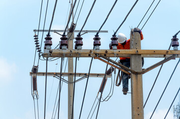 Technician men fixing or repairing broken power line on electric pole, highly dangerous work.