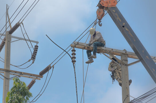 Technician Men Fixing Or Repairing Broken Power Line On Electric Pole, Highly Dangerous Work.