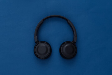 Black stereo headphones on classic blue background. Top view