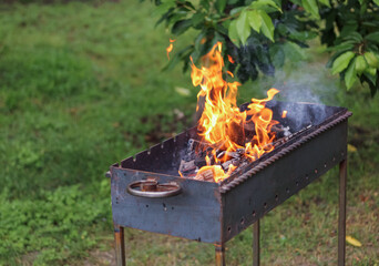Burning firewood in a barbecue for cooking barbecue outdoor