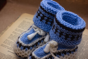 Handmade crocheted booties on an old vintage book with dried flowers