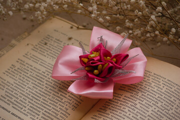 Fototapeta na wymiar Handmade hair elastic on old vintage book with dried flowers