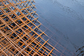 The rusty steel grid in pattern,Rusty construction metal mesh. Rusty Metal armature net for  road infrastructure  metal rebar for construction,Sites Soak in Water and Rust.