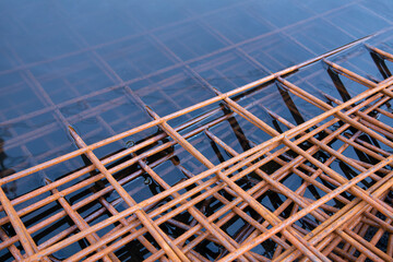 The rusty steel grid in pattern,Rusty construction metal mesh. Rusty Metal armature net for  road infrastructure  metal rebar for construction,Sites Soak in Water and Rust.